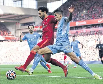  ?? AFP ?? Liverpool’s Mohamed Salah, centre, vies with Manchester City’s Joao Cancelo during their EPL match at Anfield.