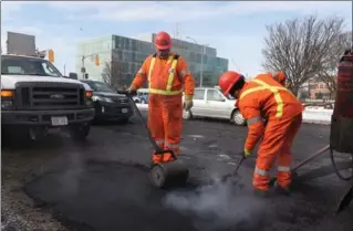  ?? SCOTT GARDNER, THE HAMILTON SPECTATOR ?? Crews from the city’s public works department, like this one on Main Street near Broadway Avenue, have been working non-stop to patch the holes with fresh asphalt.