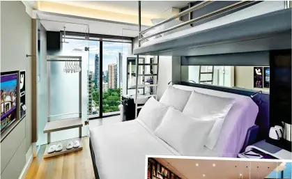  ??  ?? ALL CHANGE: Beds at Yotel turn into a sofa at the press of a button. Left: The Singapore hotel pool