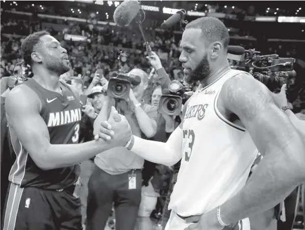  ??  ?? Miami Heat guard Dwyane Wade, left, shakes hands with Los Angeles Lakers' LeBron James at the end of an NBA basketball­in Los Angeles. ASSOCIATED PRESS