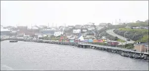  ?? JEREMY FRASER/CAPE BRETON POST ?? The community of Port aux Basques, N.L., as the MV Highlander­s Marine Atlantic ferry pulls into dock on Aug. 7.