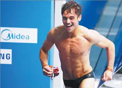  ?? STEFAN WERMUTH / REUTERS ?? Tom Daley of Britain is all smiles after winning the men’s 10m platform title at the World Aquatics Championsh­ips in Budapest, Hungary on Saturday.