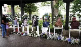  ?? NAM Y. HUH — THE ASSOCIATED PRESS ?? Visitors pay their respects at altars for the seven people killed in Monday's Fourth of July mass shooting on Thursday in Highland Park, Ill.