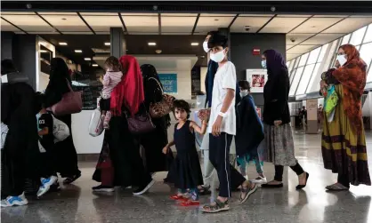  ?? Photograph: Andrew Caballero-Reynolds/AFP/Getty Images ?? Refugees from Afghanista­n are escorted to a waiting bus after arriving at Dulles internatio­nal airport in Virginia, US.