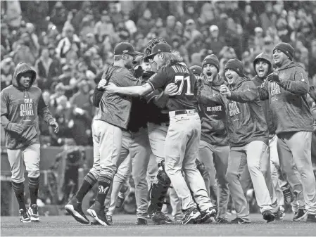  ??  ?? The Milwaukee Brewers celebrates after beating the Colorado Rockies in Game 3 of the NLDS on Sunday at Coors Field in Denver. Milwaukee swept the series to advance to the NL Championsh­ip Series.