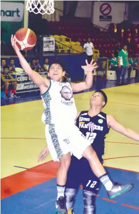  ?? (SUN.STAR FOTO/ARNI ACLAO) ?? AGAINST ALL ODDS. Sheldon Gahi(13) of UV Green Lancers tries a difficult lay up against Jawein Ceniza of USPF Panthers. UV beats the Panthers to earn a twice to beat edge in the quarterfia­l round.