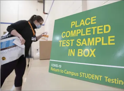  ?? COURTESY OF PENN STATE HEALTH ?? Hannah Bennett, a graduate assistant at Penn State College of Medicine in Hershey, drops off her sample during COVID-19 testing for students returning to campus in early December.