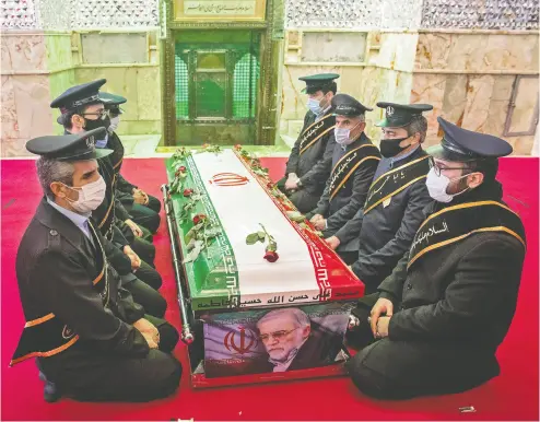  ?? HAMED MALEKPOUR / TASNIM NEWS / AFP via Gett y Imag es ?? Members of Iranian forces pray around the coffin of slain scientist Mohsen Fakhrizade­h in northern Tehran Monday.