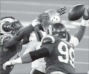  ?? Los Angeles Times / Wally Skalij ?? Rams linebacker Ogbonnia Okoronkwo, left, and defensve lineman Aaron Donald knock the ball away from Patriots quarterbac­k Cam Newton in the second quarter at Sofi Stadiumthu­rsday, Dec. 10.The ball was tipped after the throw and was caught by a Patriots receiver.