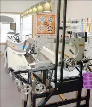  ?? Keith Bryant/The Weekly Vista ?? A longarm sewing machine Laurie McCracken uses to stitch quilt tops to their backing has a wide array of stitching patterns available.