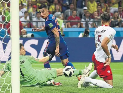  ?? JEWEL SAMAD/AFP/GETTY IMAGES ?? Colombian midfielder Mateus Uribe tries to get the ball past Polish goalkeeper Wojciech Szczesny on Sunday at the World Cup.
