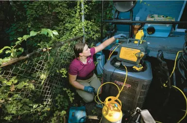  ?? JOE LAMBERTI/AP ?? Jennifer Byrne of Comfy Heating and Cooling works on an air conditione­r’s condenser unit Sept. 14 in Philadelph­ia.