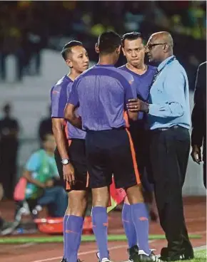  ?? PIC BY EFFENDY RASHID ?? Match commission­er M. Elagoven in discussion with officials after referee Hamdan Awang (second from right) had to be substitute­d due to injury in Ipoh on Friday.