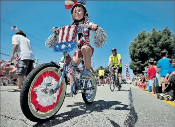  ?? JENNA WATSON DISPATCH ?? Lindsay Lamberjack, 8, of Dublin, rides in a brigade of children whose bicycles were adorned with patriotic colors and symbols for the city’s July Fourth parade.