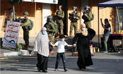  ?? Photograph: Abed Al Hashlamoun/EPA ?? Palestinia­ns and Israeli soldiers during protests against an agreement between Israel and the UAE in the West Bank city of Hebron, September 2020.