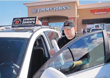  ?? JOHN LOCHER/ASSOCIATED PRESS ?? Tyler Schwecke, a delivery driver for Jimmy Johns, gets in his car to make a delivery in Las Vegas. Food delivery services like Uber Eats and GrubHub are taking off like a rocket, but some restaurant­s arent on board. This week, Jimmy Johns sandwich chain launched a national ad campaign promising never to use third-party delivery.