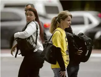  ??  ?? Mulher reage à repórter com camiseta em apoio a Jair Bolsonaro (PSL), à esq.; acima, homem observa jornalista com camiseta ‘Ele Não’, de repúdio ao candidato