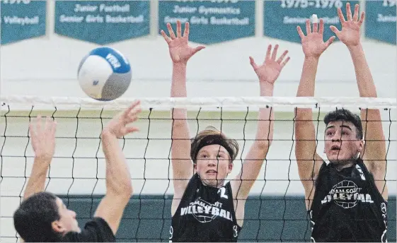  ?? CLIFFORD SKARSTEDT EXAMINER ?? Adam Scott Lions’ Jack Sweeting, left, and teammate Greg Ebisuzaki-Mackay block against Central Hastings Centurians’ Brady McCann during COSSA AA junior boys volleyball championsh­ip action on Tuesday at the Adam Scott Collegiate gym.