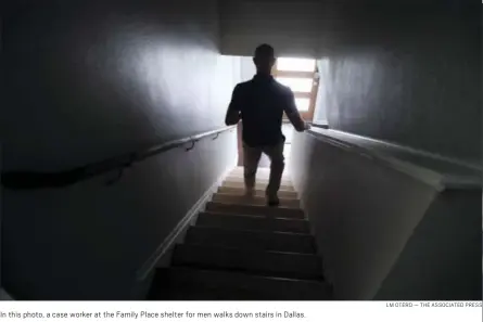  ?? LM OTERO — THE ASSOCIATED PRESS ?? In this photo, a case worker at the Family Place shelter for men walks down stairs in Dallas.