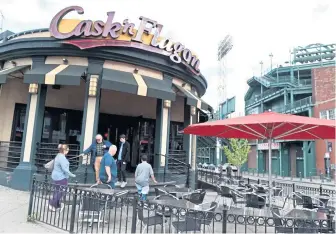  ?? JIM MICHAUD / BOSTON HERALD ?? ON DECK CIRCLE: People come and go from the the Cask ‘n Flagon in the shadow of Fenway Park, where manager Richard Flores plans to add extra staff for the World Series.