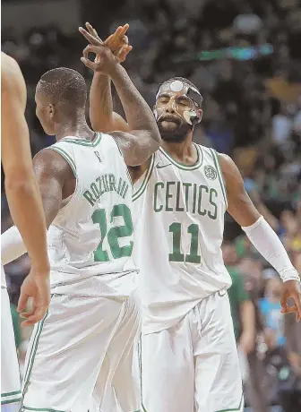  ?? STAFF PHOTO BY MATT STONE ?? FINISHING TOUCH: Kyrie Irving gives Terry Rozier a high five after the Celtics secured their win over the Mavericks last night at the Garden.