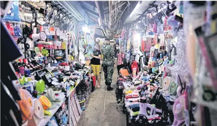  ?? AFP ?? A soldier walks past vendors at a market on the Thai-Myanmar border in Mae Sot of Tak province on Oct 29, 2020.