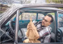  ??  ?? Patricio Chavez holds a wooden carving, or bulto, he makes and sells at his gallery in Chimayó. “We put our blood, sweat and tears in a piece like this,” Chavez said of the work.