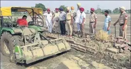  ?? HT PHOTO ?? Government officials flattening a paddy field near Sunam in Sangrur district on Tuesday.