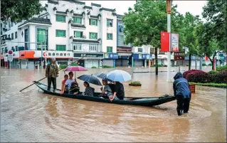  ?? FANG JUNYAO / FOR CHINA DAILY ?? Students take a boat to reach the venue for the national college entrance exam in flood-affected Shexian county, Anhui province, on Tuesday.