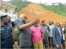  ?? — AFP ?? Sierra Leone President Ernest Bai Koroma (2nd L) visits the site of a mudslide near Freetown on Tuesday after landslides struck the capital.