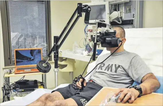  ??  ?? Virtual reality, real hope: Sergeant Oscar Liberato, a 23-year-old US soldier who was injured while with his unit in Iraq, uses the goggles and mouse as part of the Snowworld interactiv­e video game. Right: Studies show that Snowworld reduces activity in areas of the brain associated with pain perception. Photo: Steve Elliott/www.army.mil