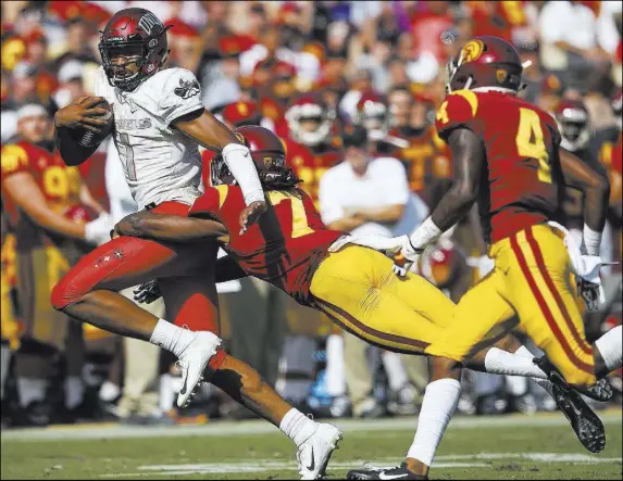  ?? Chase Stevens Las Vegas Review-Journal @csstevensp­hoto ?? Rebels quarterbac­k Armani Rogers, who ran for 82 yards, can’t escape safety Marvell Tell III in UNLV’s 43-21 loss on Saturday.