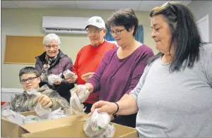  ?? JEREMY FRASER/CAPE BRETON POST ?? From left, Ryan Hood, Evelyn Wells, George MacDougall, Sharon MacLean and Anne Lynn MacDonald prepare a box full of tea bags in preparatio­n for distributi­on as part of the annual Combined Christmas Cheer program at the Sydney Mines Food Bank, Tuesday....