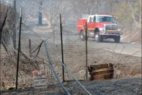  ??  ?? AP PHOTO VIA CHICO ENTERPRISE-RECORD A fire truck working on a wildfire drives past downed power lines along Lumpkin Road near Oroville, Wednesday. The wildfire is among a series of wildfires burning across the U.S. West.