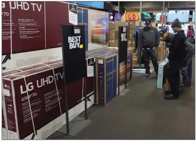  ?? (AP) ?? Customers consider a television selection at a Best Buy in Indianapol­is in this file photo. The Minneapoli­s-based consumer electronic­s chain on Tuesday reported a profit of $277 million, or $1.22 per share in the quarter that ended Oct. 29.