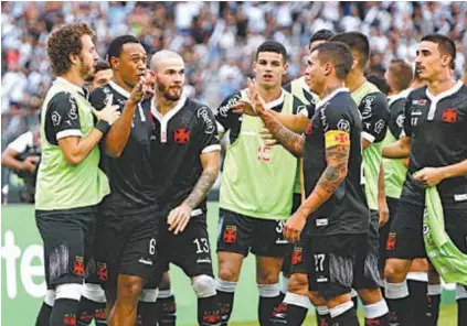  ??  ?? Fabrício (segundo, à esquerda) é festejado pelos companheir­os após fazer a jogada do primeiro gol do Vasco