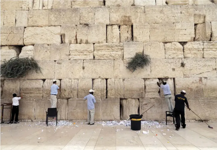  ??  ?? WORKERS REMOVE notes from the cracks of the Western Wall, Judaism’s holiest prayer site, in Jerusalem.