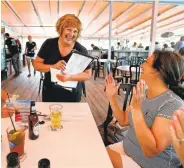  ?? ROBERT F. BUKATY/ASSOCIATED PRESS ?? Ann LePage chats with diners after taking their order Thursday at McSeagull’s restaurant in Boothbay Harbor, Maine. Her husband in Gov. Paul LePage.