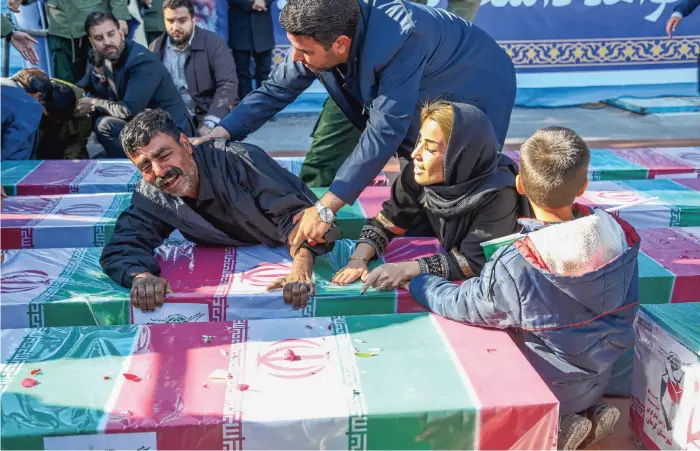  ?? ?? Familieled­en rouwen in januari om slachtoffe­rs van een bomaanslag door terreurgro­ep IS-K in Kerman, Iran, bij een herdenking van de in 2020 door de VS geliquidee­rde generaal Qasem Soleimani.