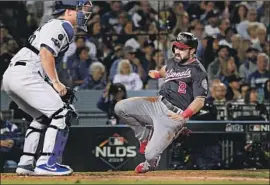  ?? Wally Skalij Los Angeles Times ?? ADAM EATON scores past Dodgers catcher Will Smith on a double off Clayton Kershaw in the second inning in Game 2 as the Nationals took a 3-0 lead.