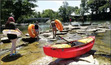  ?? NWA Democrat-Gazette/FLIP PUTTHOFF ?? Youngsters walk to the top of the run for a thrilling tube ride. The free park offers a run through rapids, plus calm water for swimming.