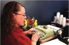  ??  ?? Andrea Kittle tries out a vintage Smith Corona electric typewriter at a "type-in" in Albuquerqu­e.