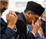  ?? Annie Mulligan ?? Munawar Choudhry prays during a candleligh­t vigil rememberin­g victims of violence, most recently the attacks in New York City and Sutherland Springs.