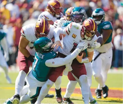  ?? ALEX BRANDON/AP ?? Washington Commanders quarterbac­k Carson Wentz is sacked by Philadelph­ia Eagles linebacker Haason Reddick, left, and defensive end Brandon Graham on Sept. 25 in the first meeting between the two teams this season. Wentz, who will not play Monday night, was sacked nine times and the Eagles won 24-8.