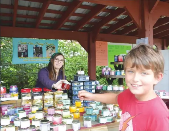  ?? PHOTO COURTESY ETHAN BALL ?? Jacob Vanier gives a jar of jam to a vendor at the Potton Market.