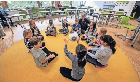 ?? RP-FOTO: MARKUS VAN OFFERN ?? Schulleite­r Jens Willmeroth mit Schülern im Sitzkreis. Spiel- und Sportangeb­ote wechseln sich mit Unterricht ab.