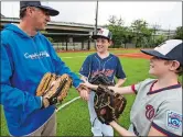  ?? MANUEL BALCE CENETA/AP PHOTO ?? David Fox, from left, sons Dewey and Jimmy, put their hands together as they wrap up practicing baseball at a nearby field in northeast Washington on Friday.