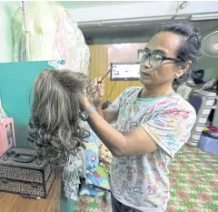  ??  ?? Makeup artist Lynn Lynn cleans her wig collection in her studio in Yangon.