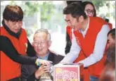  ?? PROVIDED TO CHINA DAILY ?? Li Gan, developer of the Love Hula Hoop app (third from left), helps hand out gifts in January to bereaved parents in Shenzhen, Guangdong province.