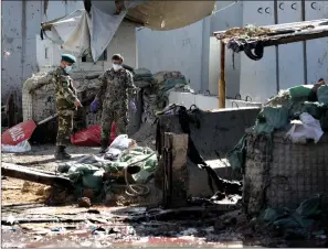  ?? Associated Press ?? ■ Afghan security forces work at the site of a suicide attack Tuesday near the U.S. Embassy in Kabul, Afghanista­n. Hours earlier Afghan officials said a suicide bomber rammed his motorcycle packed with explosives into the entrance to a campaign rally of President Ashraf Ghani in northern Parwan province. Ghani was present at the venue but was unharmed. The Taliban has claimed both attacks.